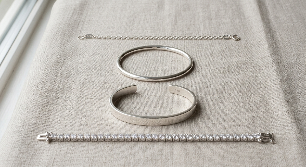 Four 925 sterling silver bracelets in chain, bangle, cuff and tennis styles
