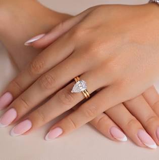 Lab-grown diamond eternity ring stacked with engagement ring and wedding band on left hand