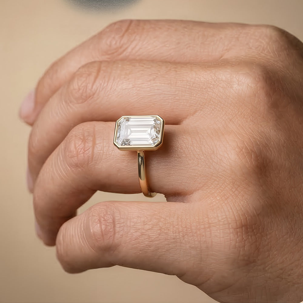 Emerald cut moissanite solitaire ring on hand Finger