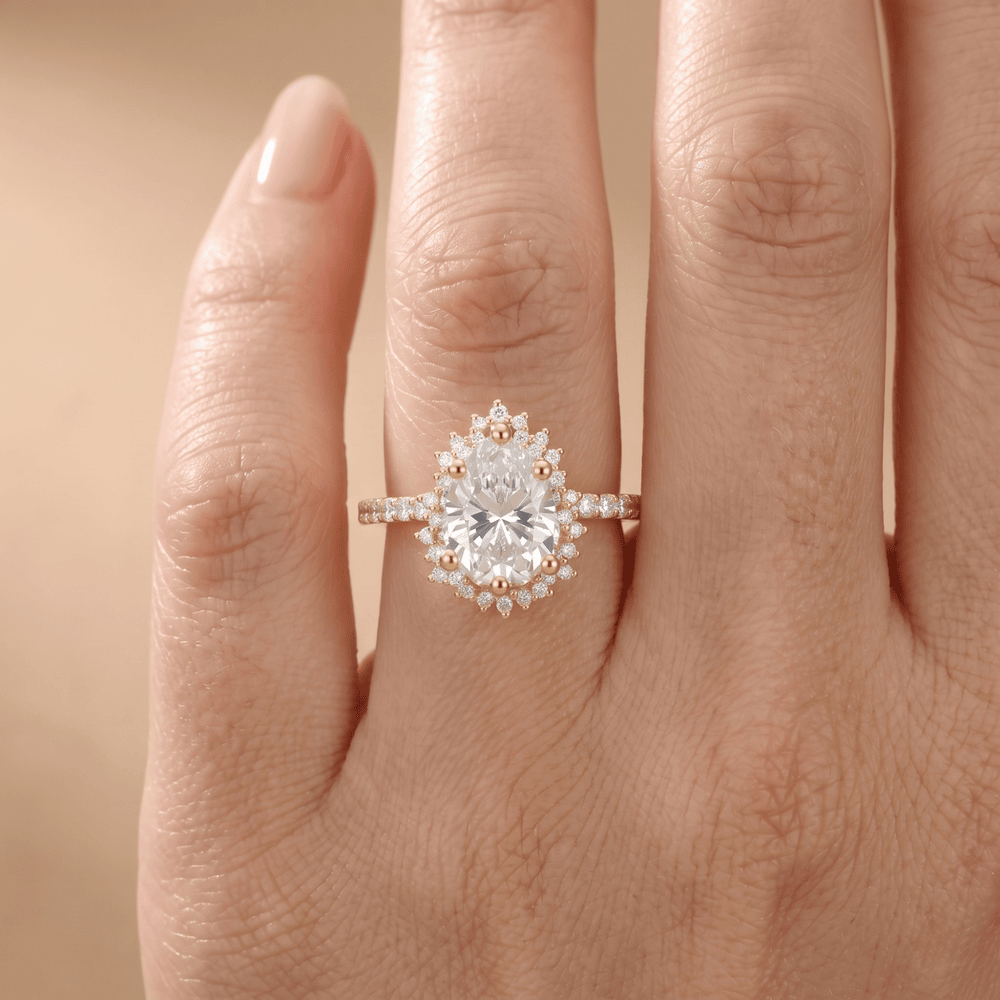 A close-up of a hand wearing a rose gold halo engagement ring with a large round-cut center stone and smaller accent stones.
