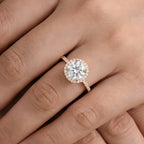 Halo engagement ring worn on model's hand