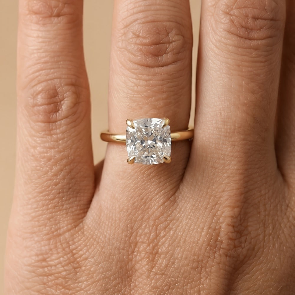 Cushion cut solitaire diamond ring on model's hand
