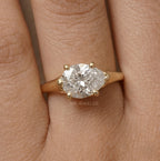 East-west pear moissanite ring styled on model's hand