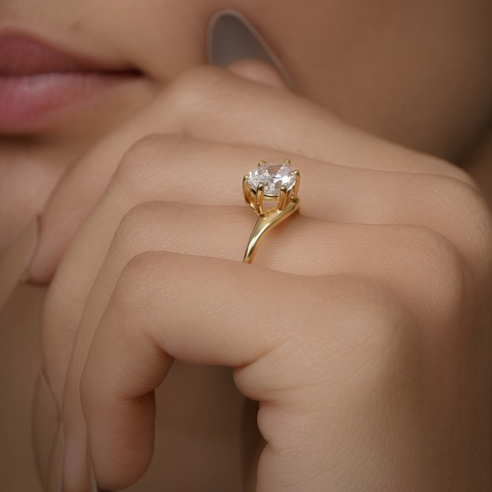 East-west pear moissanite ring styled on model's hand