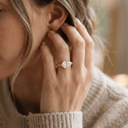 East-west pear moissanite ring styled on model's hand