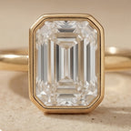 Emerald cut diamond ring in sleek bezel setting close up