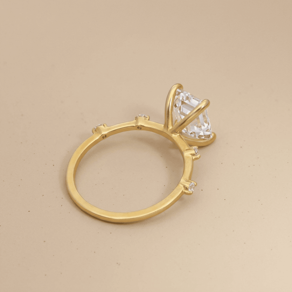 Close-up of emerald cut moissanite gold engagement ring