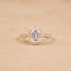Halo ring with emerald cut center stone