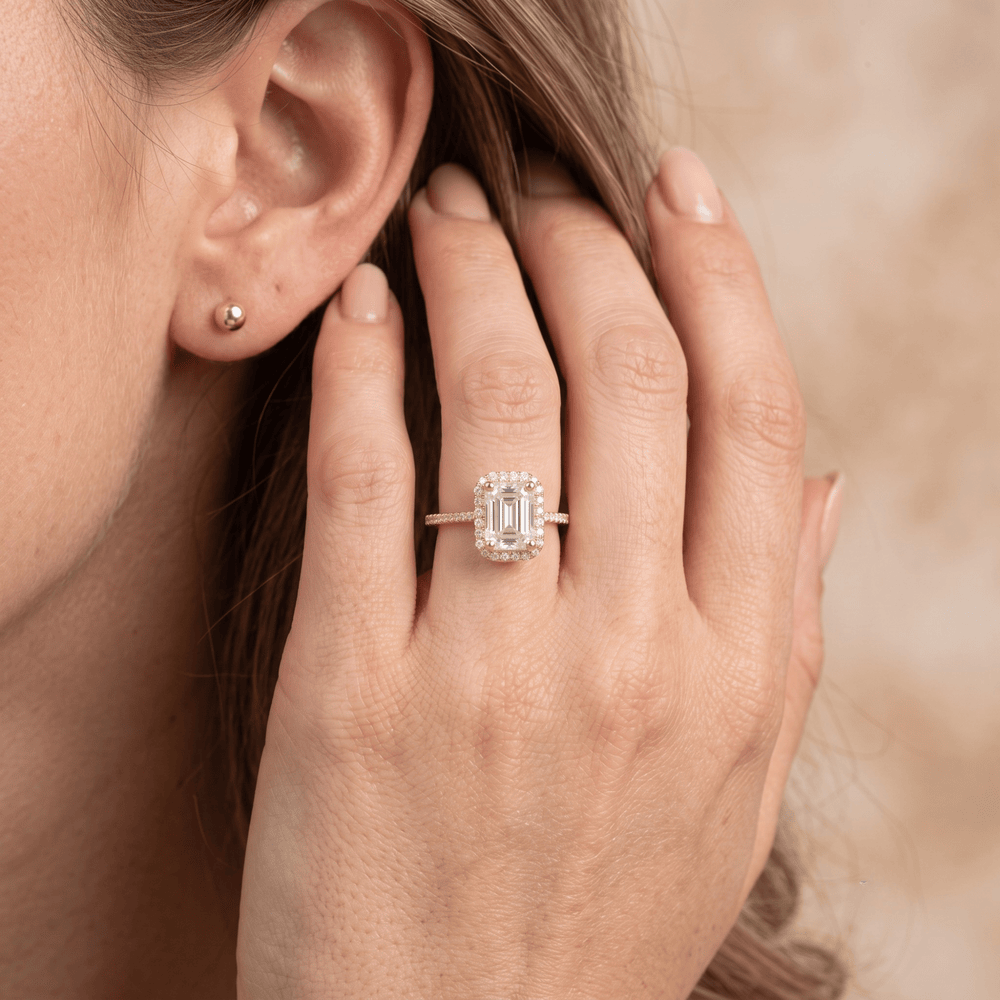 Emerald cut halo ring on model's hand