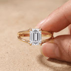 Emerald cut split shank solitaire ring on model's hand