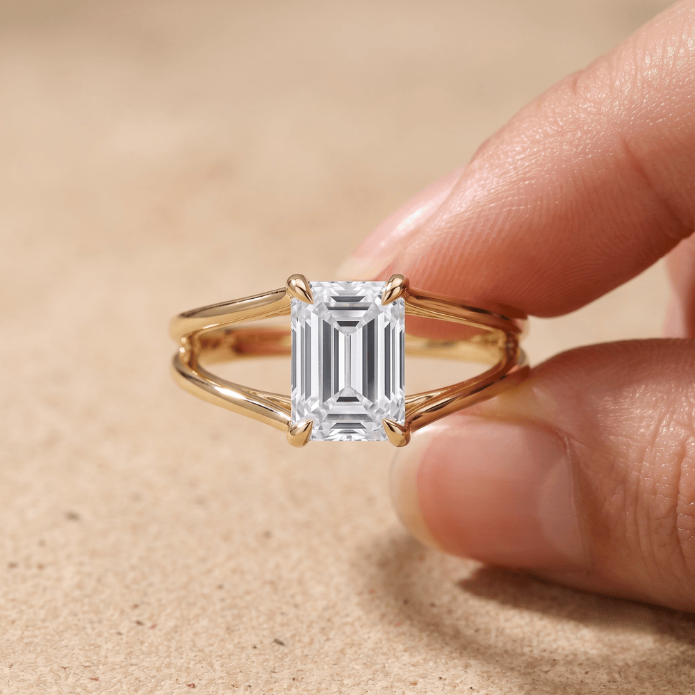 Emerald cut split shank solitaire ring on model's hand