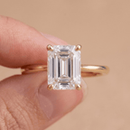 Emerald moissanite solitaire ring close-up on hand