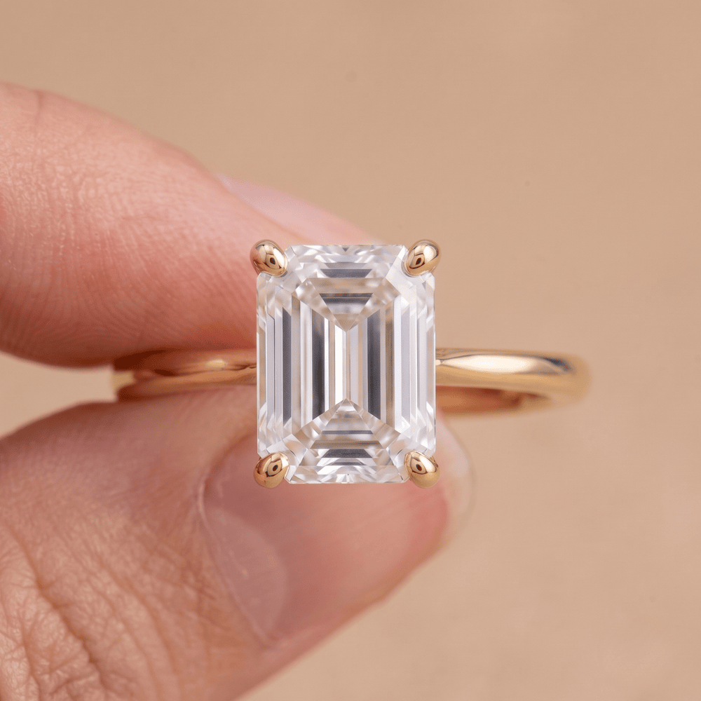 Emerald moissanite solitaire ring close-up on hand