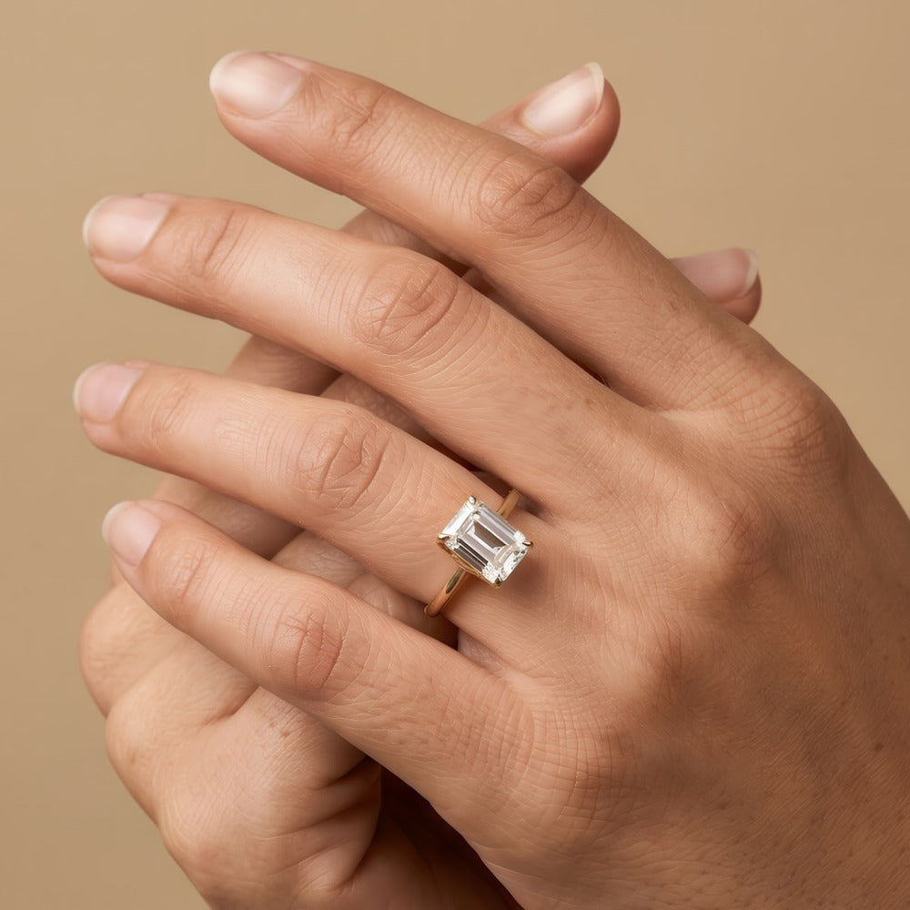 Emerald moissanite solitaire ring close-up on hand Finger