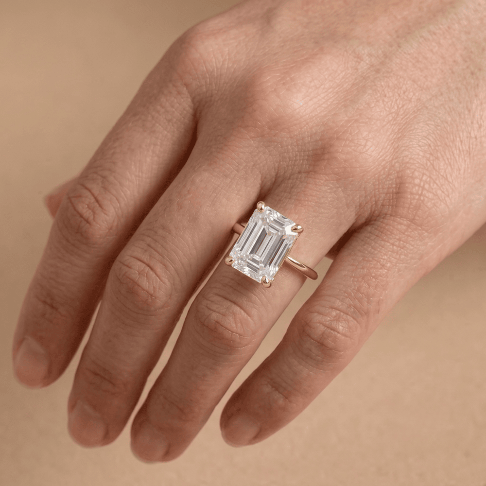 Emerald moissanite solitaire ring close-up on hand Finger