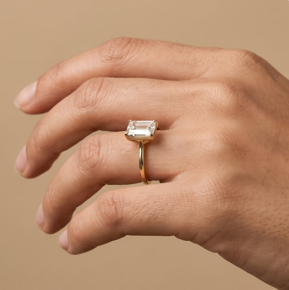 Emerald moissanite solitaire ring close-up on hand Finger side view