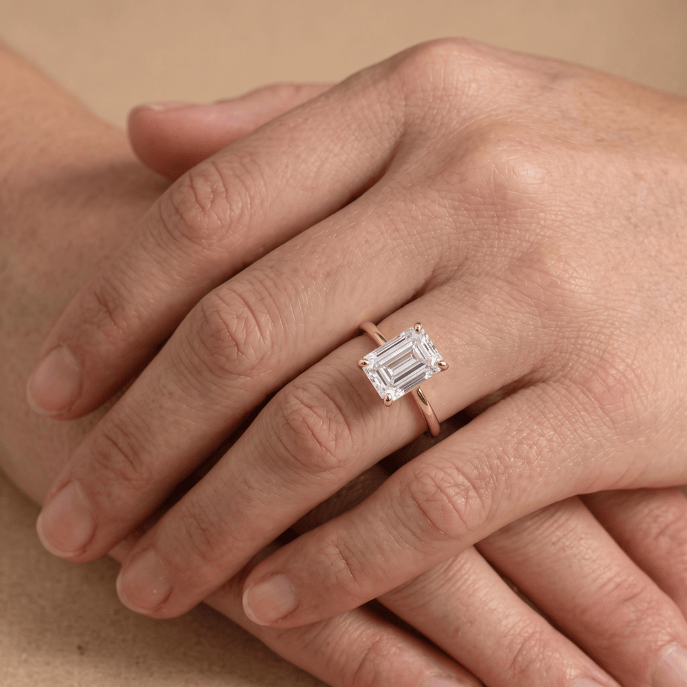 Emerald moissanite solitaire ring close-up on hand Finger