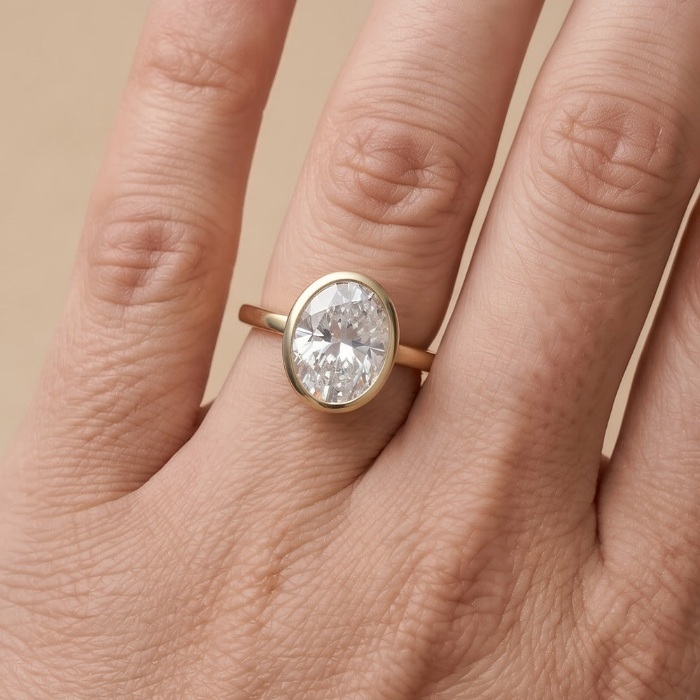 Bezel set oval diamond proposal ring on hand