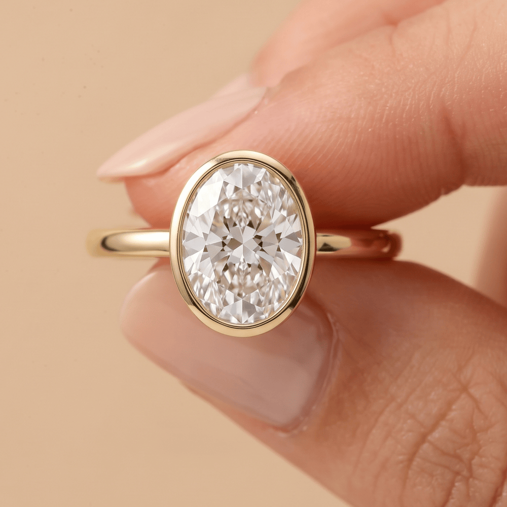 Bezel set oval diamond proposal ring on hand