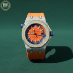 Luxury watch with orange face and orange strap on a green background, featuring JBR Jeweler