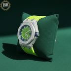 Luxury watch with green strap and diamond-studded case on a green cushion, JBR Jeweler