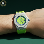 Luxury watch with green strap and blue face on a wrist, brand 'JBR' visible.