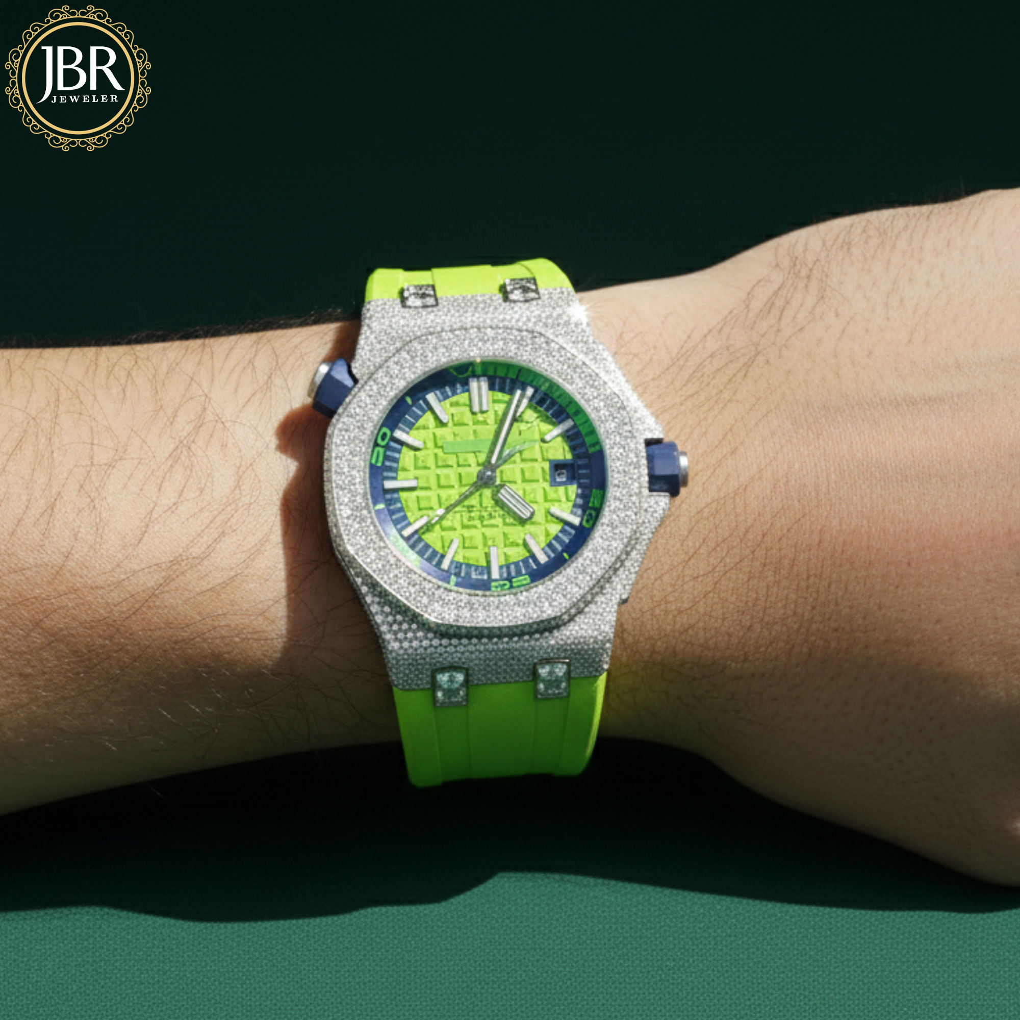 Luxury watch with green strap and blue face on a wrist, brand 'JBR' visible.