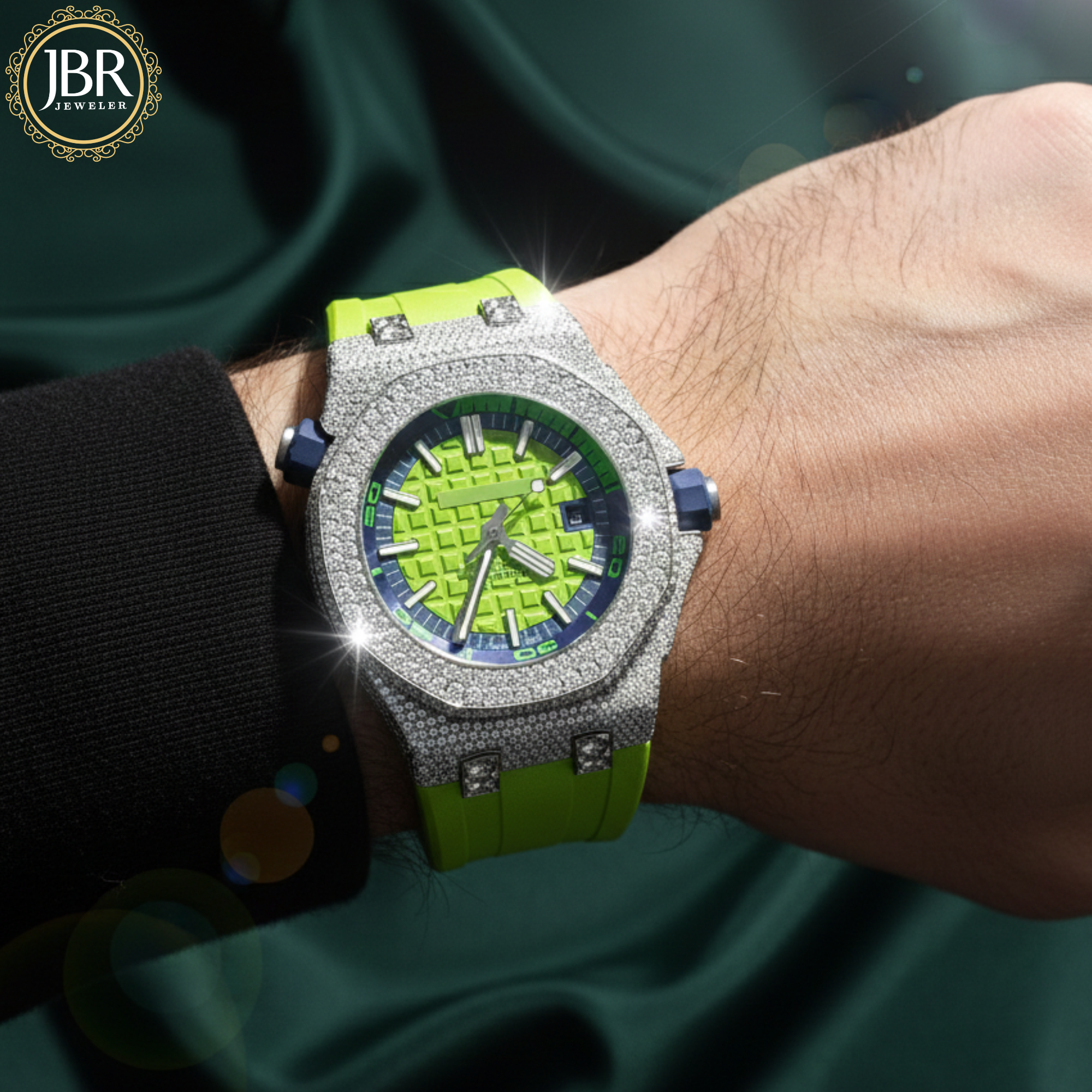 Luxury watch with green strap and diamond-studded case on a wrist, brand 'JBR' 