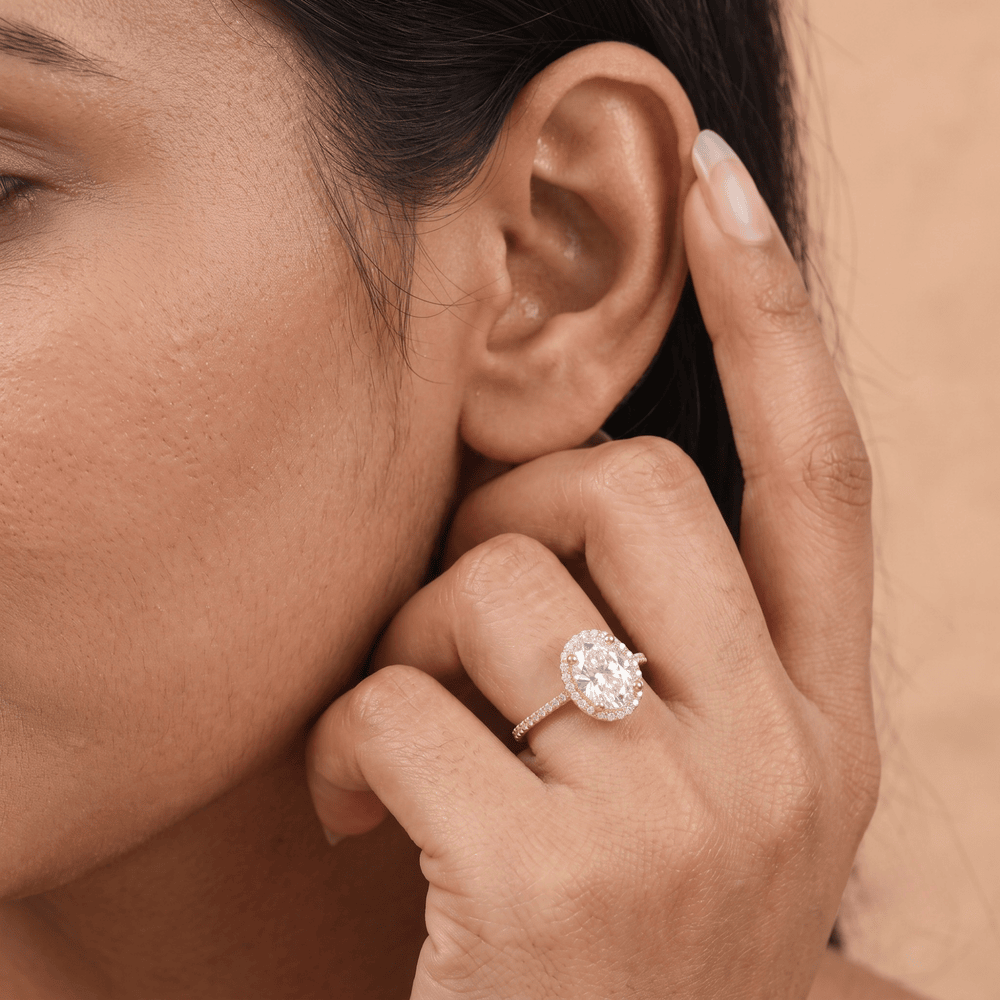 Oval halo diamond ring styled on model's hand