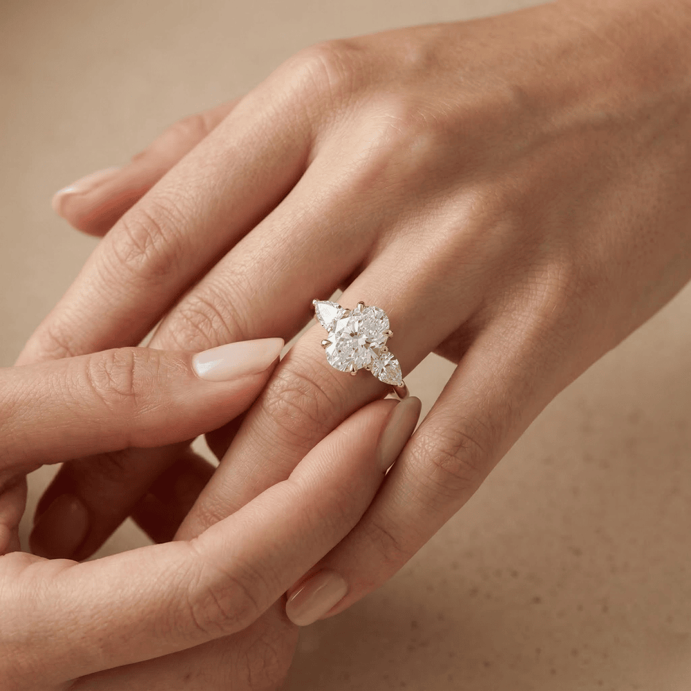Classic oval three stone gold engagement ring