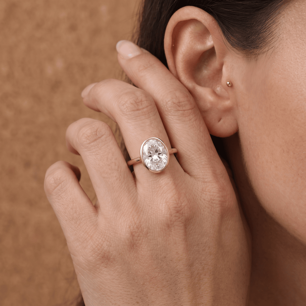 Oval bezel moissanite ring on hand
