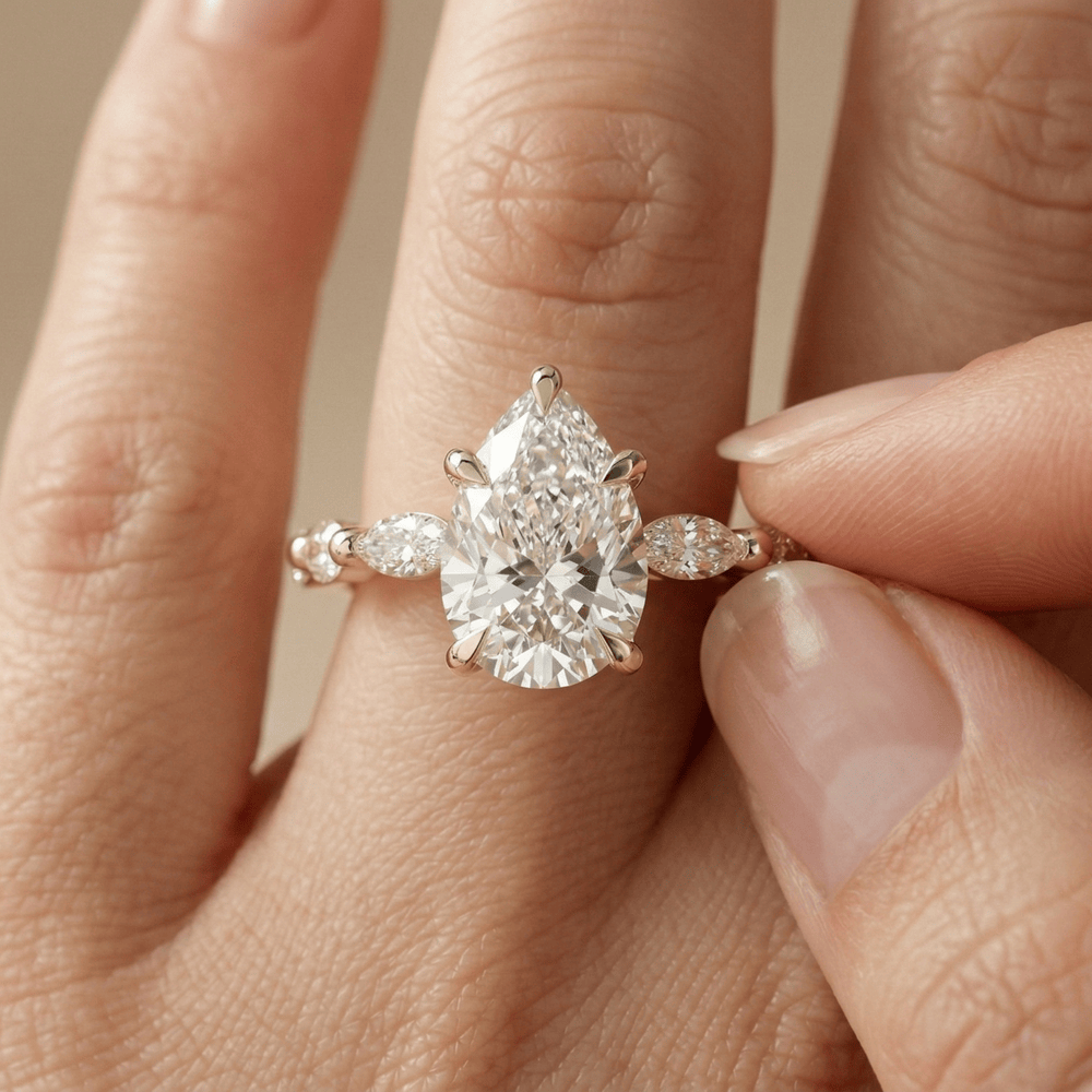Pear cut diamond ring with side stones in yellow gold