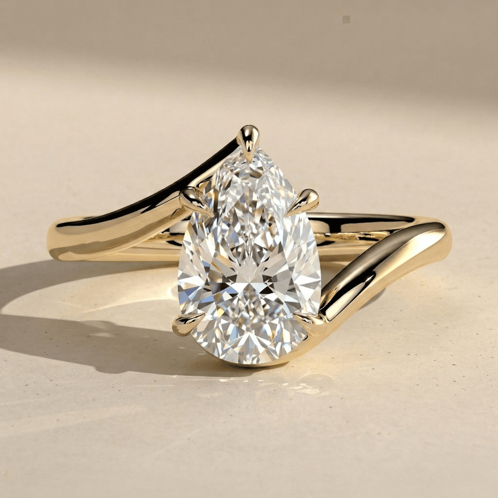 Pear cut lab grown diamond bypass ring with elegant gold band