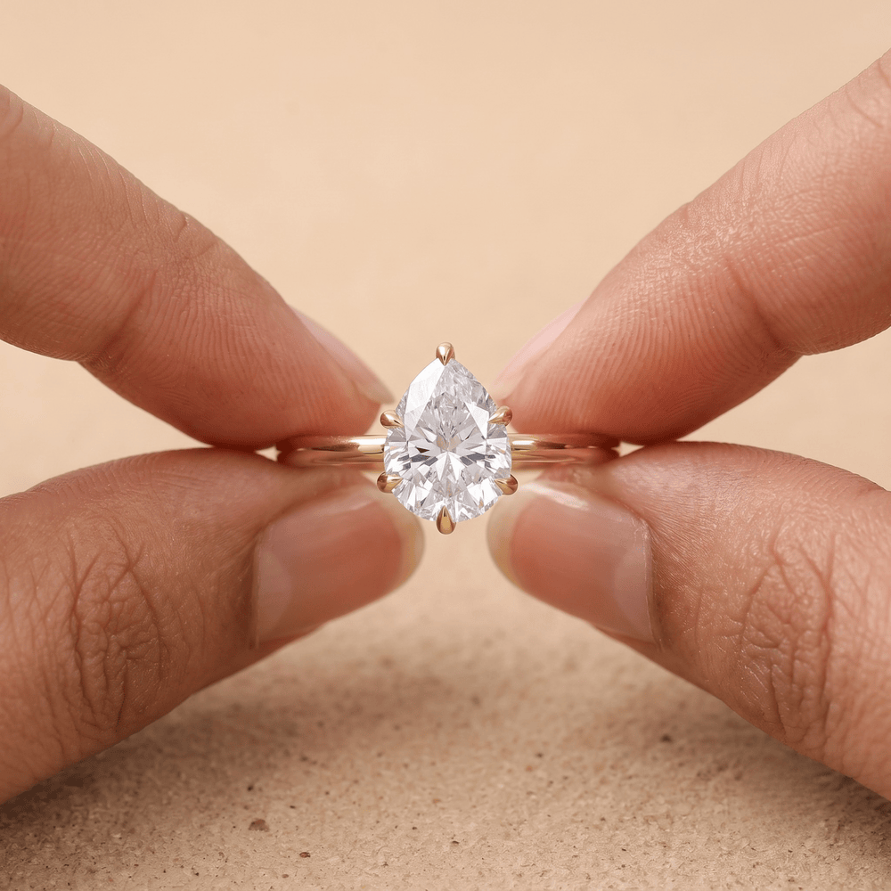 Pear cut diamond engagement ring on model's hand