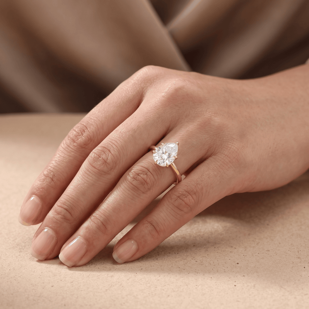 Pear cut diamond engagement ring on model's hand