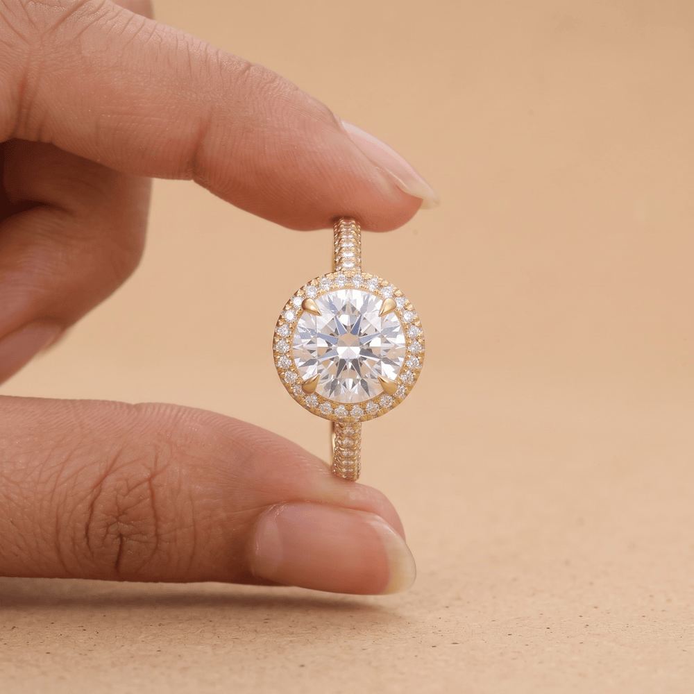 Round cut halo ring on model's hand, natural lighting