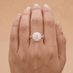 Round cut halo ring on model's hand, natural lighting