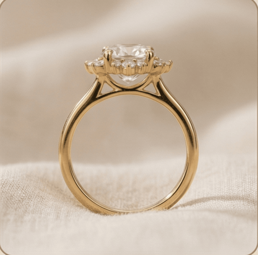 A yellow gold ring with a large clear round-cut center stone and small side stones, photographed close up on a soft beige fabric background.