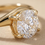 Close-up of round moissanite solitaire on 14K gold curved band