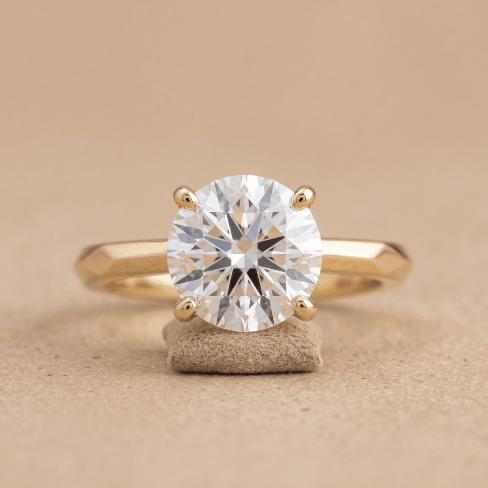 Round moissanite solitaire ring with 14K vintage band front view