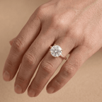 Round moissanite proposal ring with vintage detailing on finger