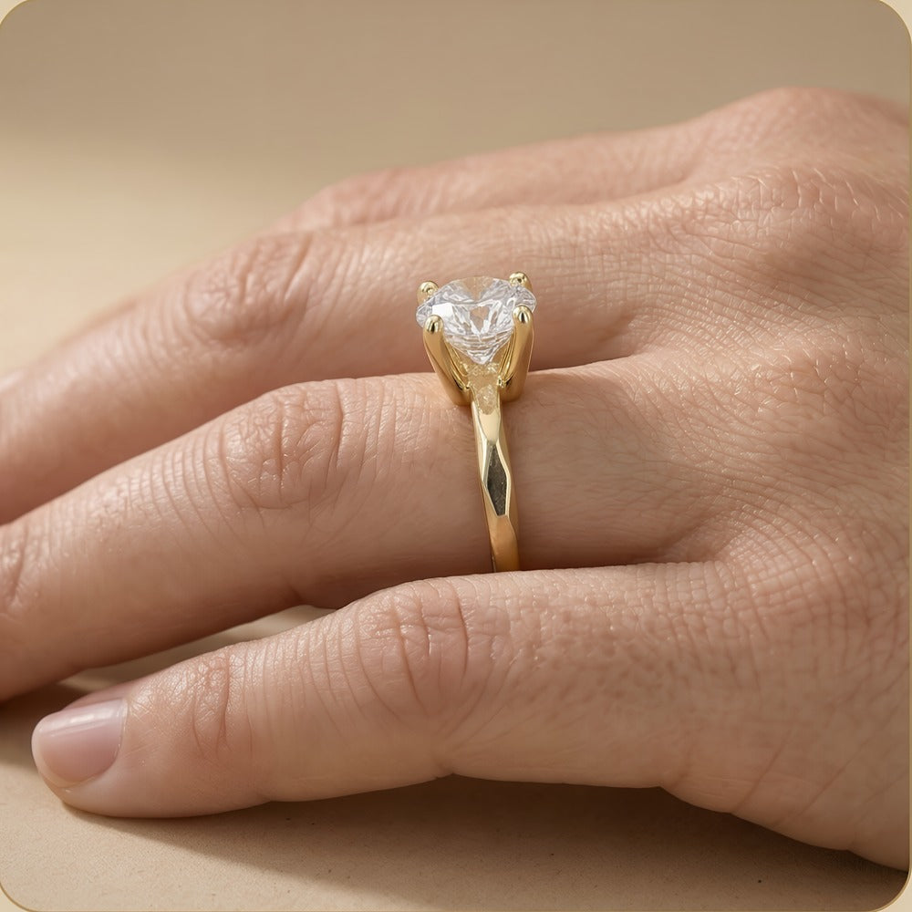 Round solitaire ring on model's hand finger side view