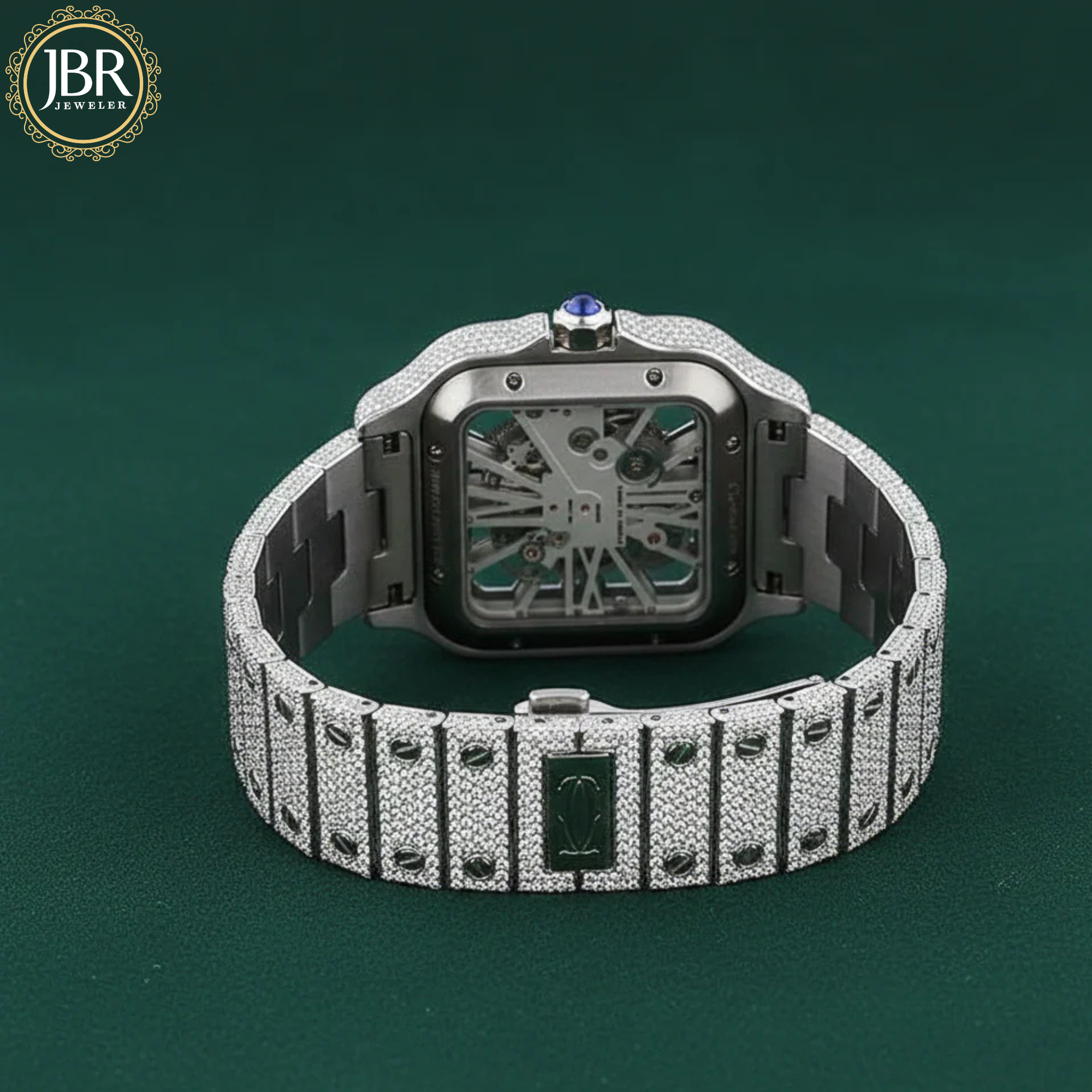 Luxury diamond-encrusted watch on a dark green background with JBR Jewels logo.