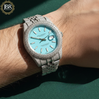 Luxury watch with turquoise face and diamond-studded case on a wrist, brand 'JBR' 