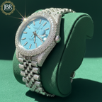 Luxury watch with diamond-studded case on a green stand, featuring JBR Jeweler