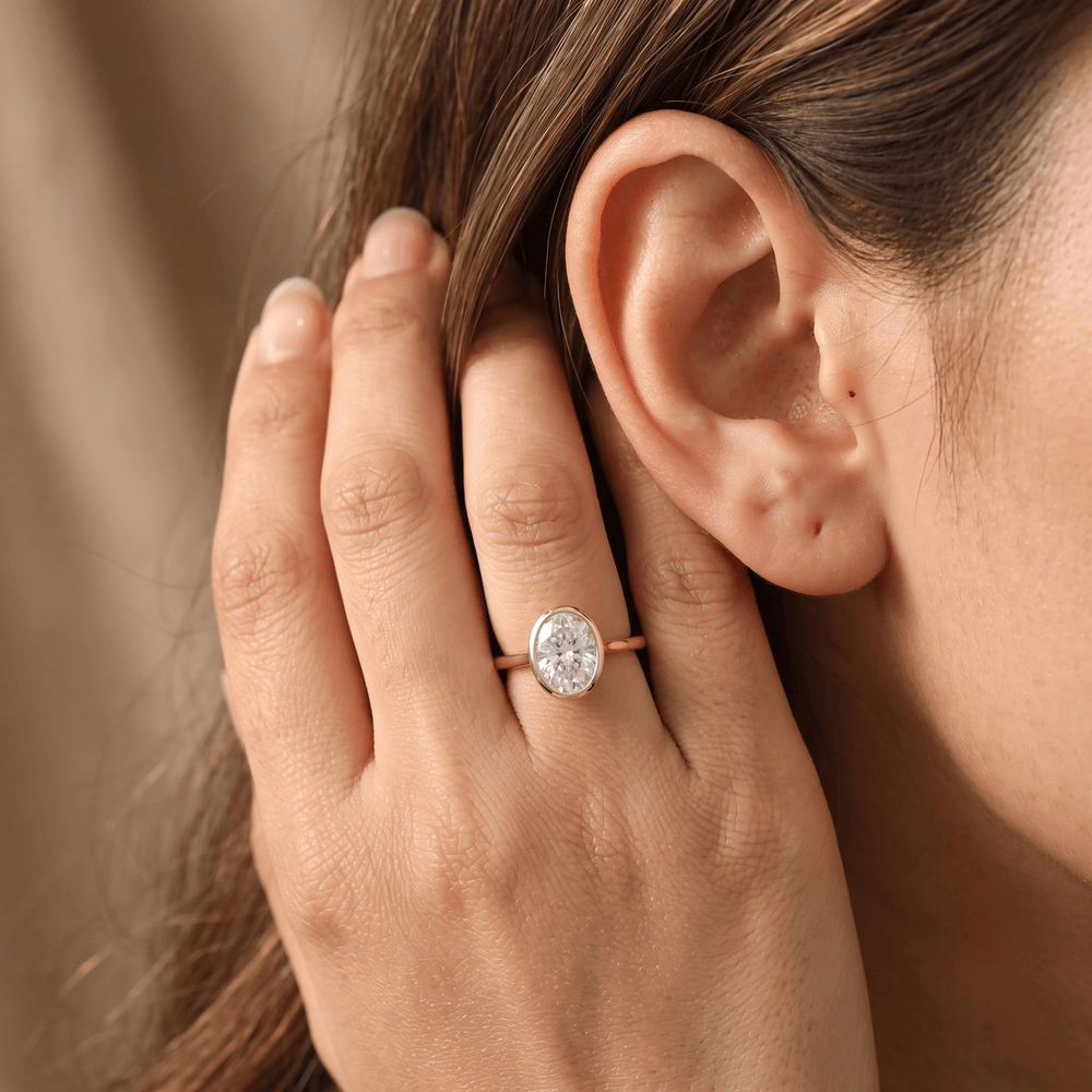 Oval solitaire bezel ring set in white gold