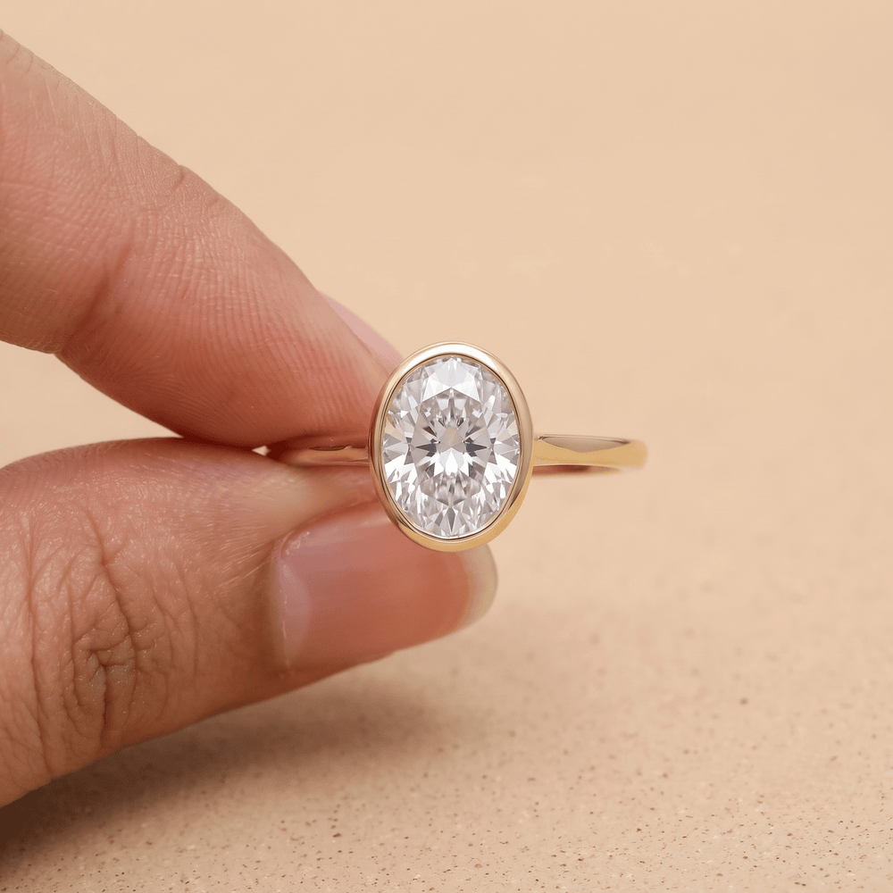 His and hers solitaire bezel rings on display