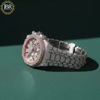 Luxury diamond-encrusted watch on a green background with JBR Jewellers logo.