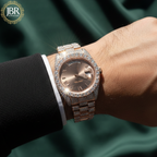 Rose gold diamond-encrusted watch on a wrist with a green satin background, featuring JBR Jewellers