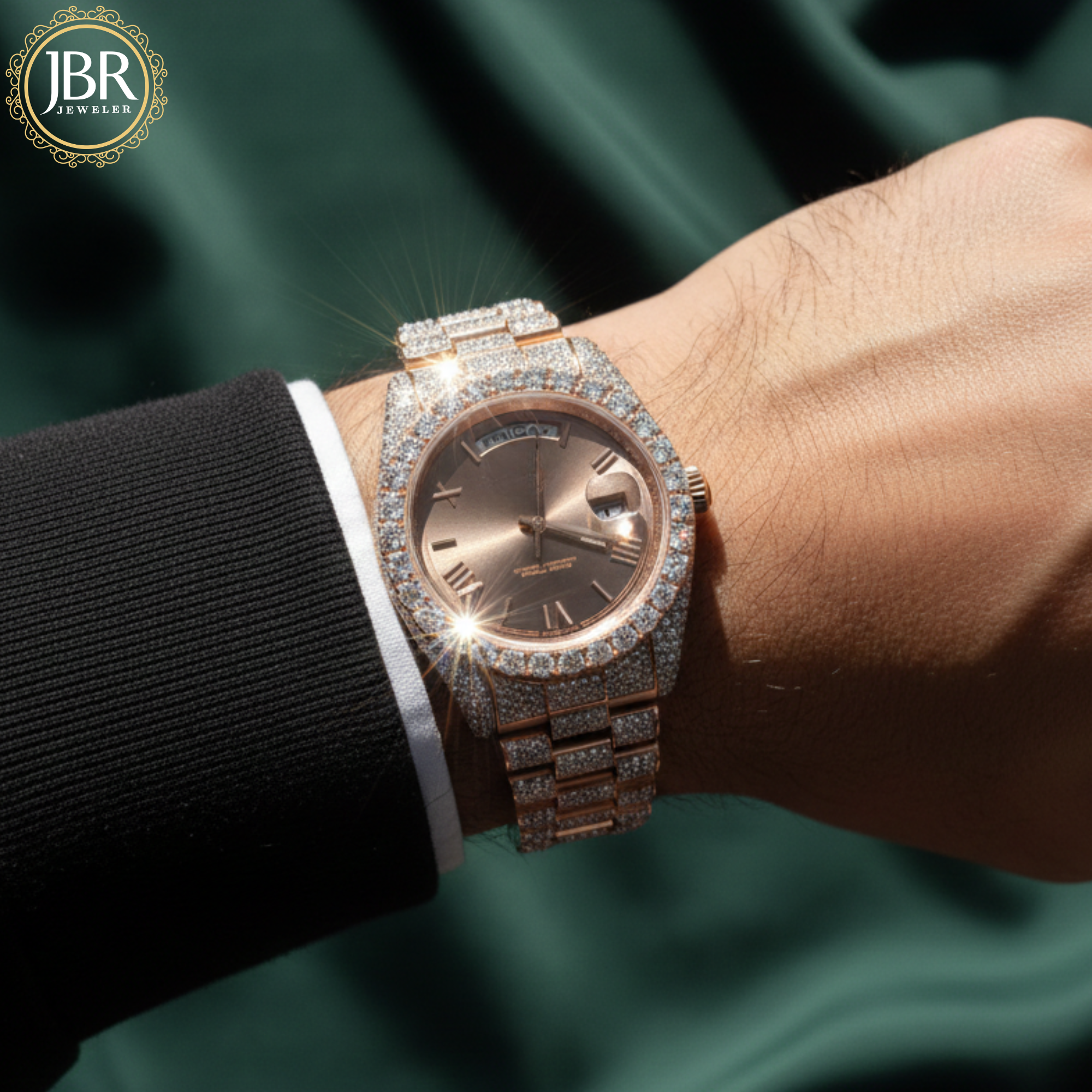 Rose gold diamond-encrusted watch on a wrist with a green satin background, featuring JBR Jewellers